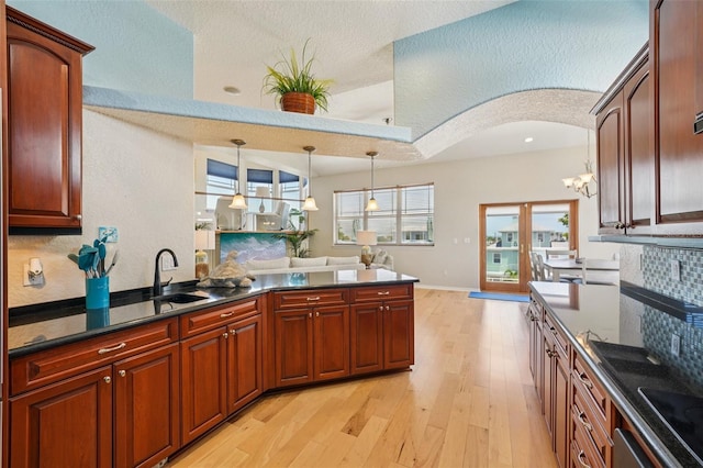 6543 Louise Ct, Hudson, FL 34667 - kitchen featuring dark countertops, light wood-style flooring, and decorative light fixtures