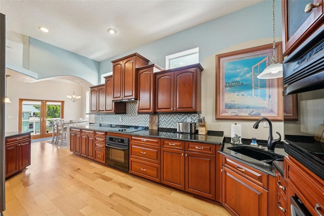 6543 Louise Ct, Hudson, FL 34667 - kitchen with black appliances, a chandelier, dark countertops, decorative backsplash, and hanging light fixtures