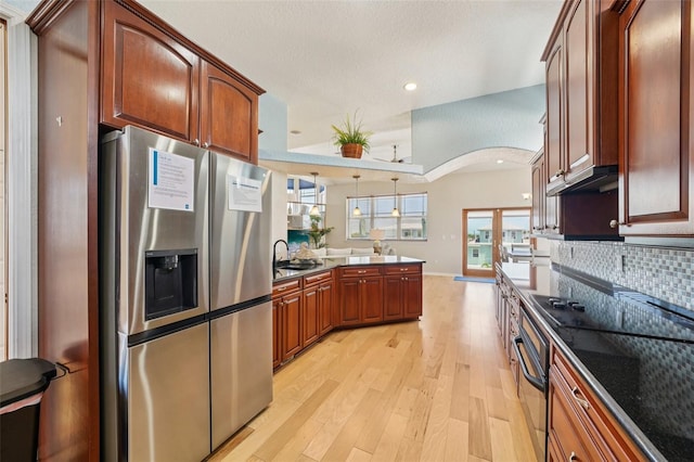 6543 Louise Ct, Hudson, FL 34667 - kitchen featuring stainless steel fridge with ice dispenser, a peninsula, arched walkways, light wood-style flooring, and backsplash