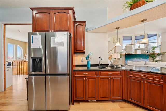 6543 Louise Ct, Hudson, FL 34667 - kitchen with stainless steel refrigerator with ice dispenser, dark countertops, decorative light fixtures, and light wood finished floors