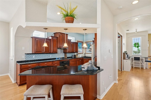 6543 Louise Ct, Hudson, FL 34667 - kitchen with tasteful backsplash, dark countertops, arched walkways, light wood-type flooring, and recessed lighting