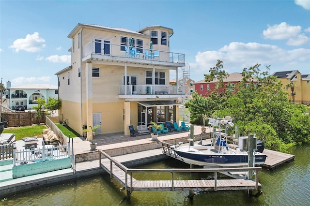 6543 Louise Ct, Hudson, FL 34667 - rear view of house featuring a balcony, a water view, a fenced backyard, a patio, and boat lift