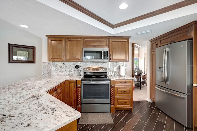 9619 Towanda Ln, Port Richey, FL 34668 - kitchen featuring appliances with stainless steel finishes, backsplash, ornamental molding, brown cabinets, and recessed lighting