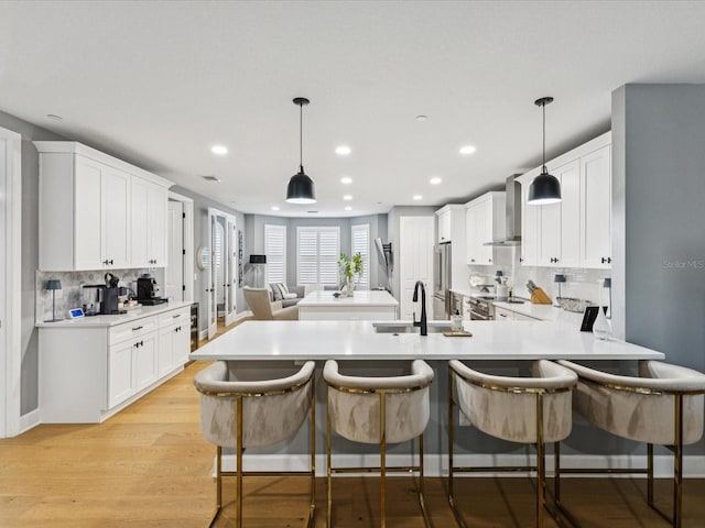 1340 Bayshore Blvd Unit 502, Dunedin, FL 34698 - kitchen featuring wall chimney exhaust hood, recessed lighting, a peninsula, a breakfast bar area, and backsplash