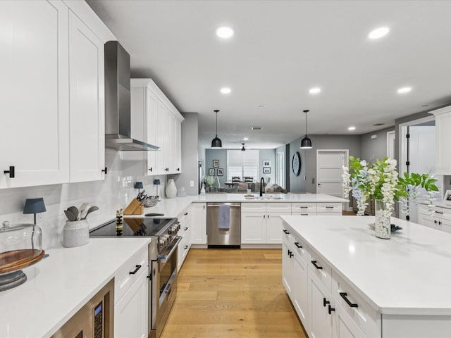 1340 Bayshore Blvd Unit 502, Dunedin, FL 34698 - kitchen featuring appliances with stainless steel finishes, wall chimney range hood, a peninsula, recessed lighting, and light countertops
