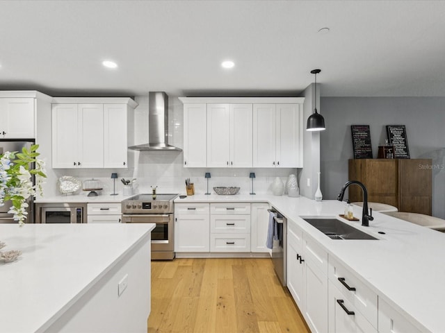 1340 Bayshore Blvd Unit 502, Dunedin, FL 34698 - kitchen with wall chimney exhaust hood, appliances with stainless steel finishes, light countertops, white cabinetry, and recessed lighting
