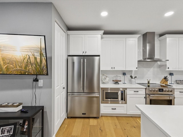 1340 Bayshore Blvd Unit 502, Dunedin, FL 34698 - kitchen featuring appliances with stainless steel finishes, wall chimney exhaust hood, light countertops, recessed lighting, and white cabinets
