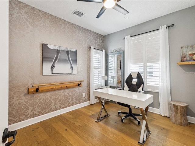 1340 Bayshore Blvd Unit 502, Dunedin, FL 34698 - home office with wallpapered walls, wood finished floors, a ceiling fan, and an accent wall