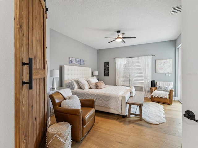 1340 Bayshore Blvd Unit 502, Dunedin, FL 34698 - bedroom featuring light wood-style floors, a textured ceiling, and ceiling fan