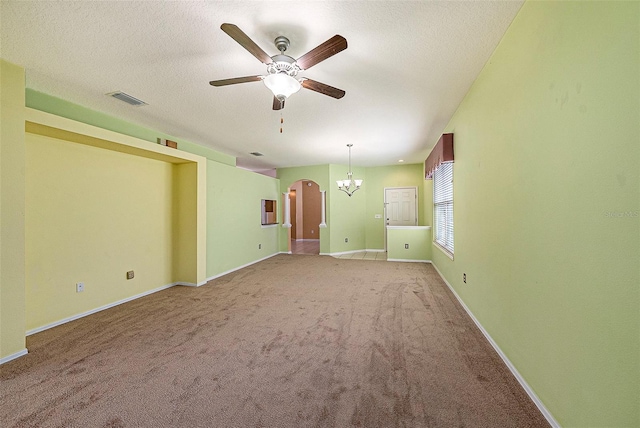 1914 Sassafras Dr, Wesley Chapel, FL 33543 - unfurnished living room with ceiling fan, arched walkways, light carpet, a chandelier, and a textured ceiling