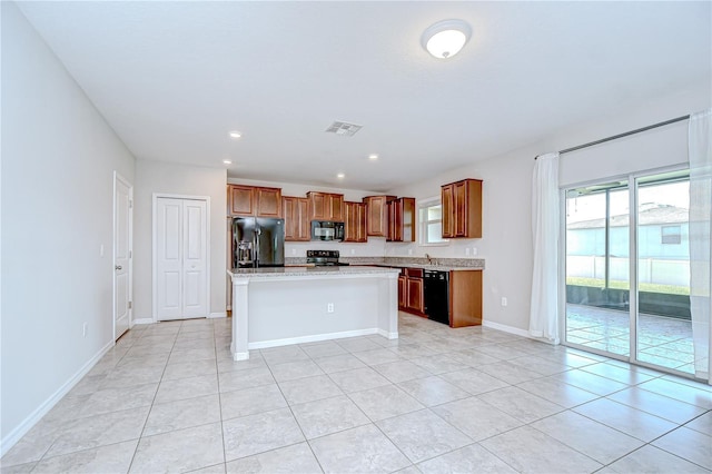 208 English Heritage Pl, Dover, FL 33527 - kitchen featuring black appliances, light countertops, brown cabinetry, light tile patterned flooring, and a center island