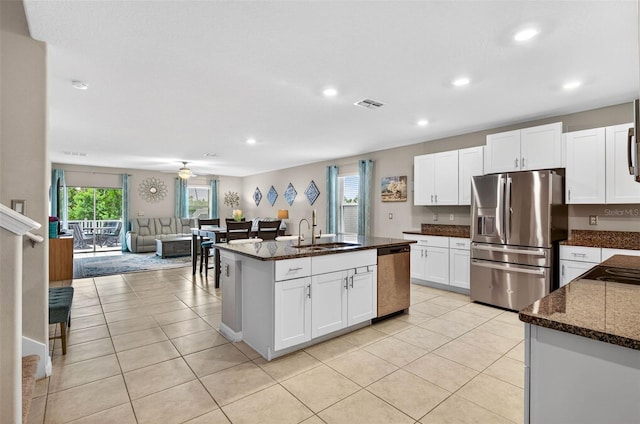 12835 Wildflower Meadow Dr, Riverview, FL 33579 - kitchen featuring stainless steel appliances, recessed lighting, dark stone counters, open floor plan, and white cabinets