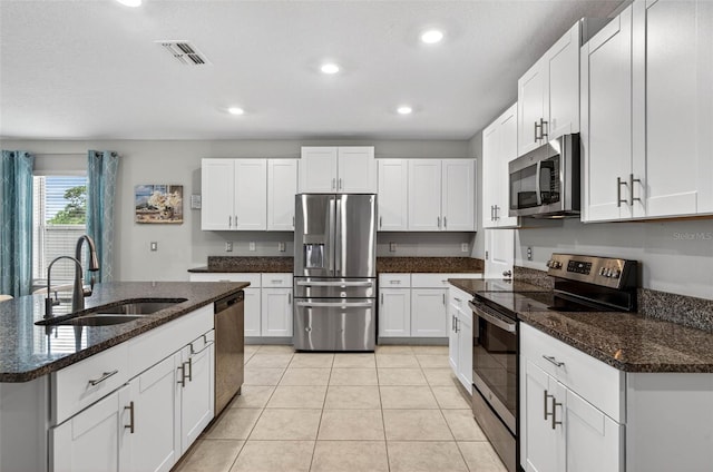 12835 Wildflower Meadow Dr, Riverview, FL 33579 - kitchen featuring appliances with stainless steel finishes, recessed lighting, white cabinetry, dark stone countertops, and light tile patterned flooring