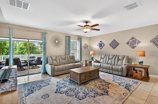 12835 Wildflower Meadow Dr, Riverview, FL 33579 - living room with tile patterned floors, a ceiling fan, and a textured ceiling