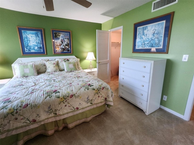 400 64th Ave Unit 1105, St Pete Beach, FL 33706 - bedroom with light carpet, a walk in closet, a closet, and a ceiling fan