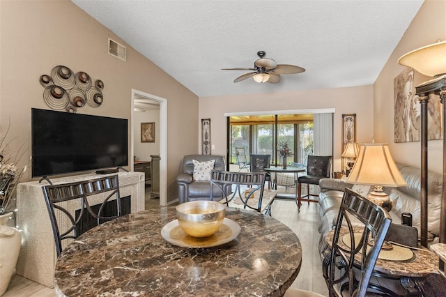 2922 60th St W, Bradenton, FL 34209 - living room featuring vaulted ceiling, ceiling fan, light wood-style floors, and a textured ceiling