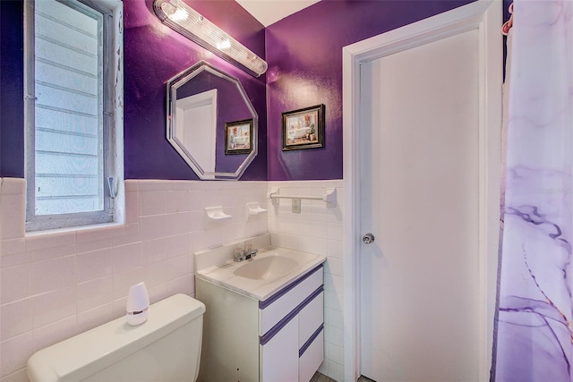 11082 90th Ter, Seminole, FL 33772 - bathroom featuring vanity, tile walls, and a wainscoted wall