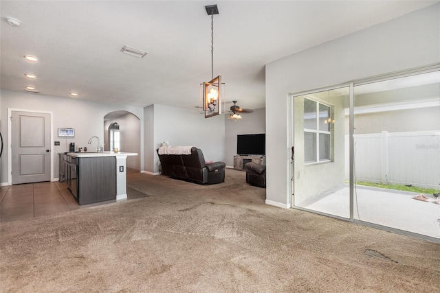 15406 Gopher Trop Pl, Sun City Center, FL 33573 - living area with light colored carpet, arched walkways, a ceiling fan, and recessed lighting