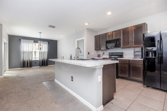 15406 Gopher Trop Pl, Sun City Center, FL 33573 - kitchen with black appliances, light countertops, dark brown cabinetry, a kitchen island with sink, and light tile patterned flooring