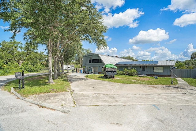 9938 Alavista Dr, Gibsonton, FL 33534 - view of front of home featuring roof mounted solar panels, concrete driveway, and a metal roof