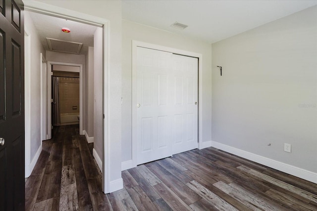 706 E Gate Dr, Safety Harbor, FL 34695 - unfurnished bedroom with dark wood finished floors, a closet, and attic access