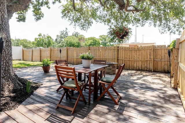 706 E Gate Dr, Safety Harbor, FL 34695 - wooden terrace featuring outdoor dining space and a fenced backyard