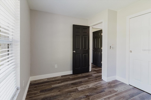 706 E Gate Dr, Safety Harbor, FL 34695 - unfurnished bedroom featuring dark wood-style floors and baseboards