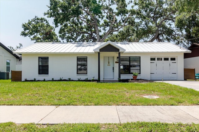 706 E Gate Dr, Safety Harbor, FL 34695 - view of front of property with a standing seam roof, an attached garage, stucco siding, a front lawn, and a metal roof