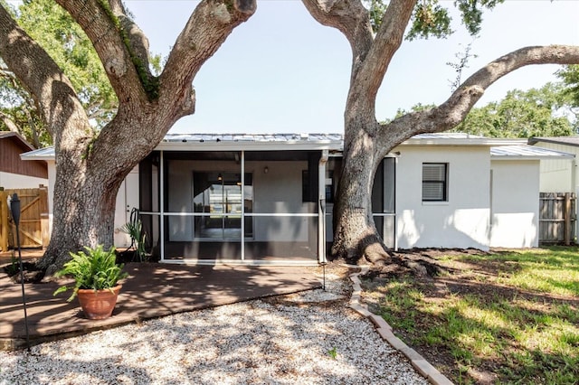 706 E Gate Dr, Safety Harbor, FL 34695 - view of front of property with a patio, stucco siding, a metal roof, a sunroom, and a standing seam roof