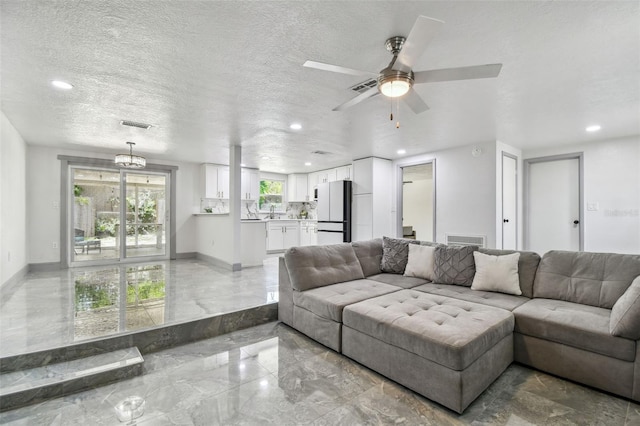 6200 13th Ave, New Port Richey, FL 34653 - living area featuring light marble finish floors, recessed lighting, a ceiling fan, and a textured ceiling