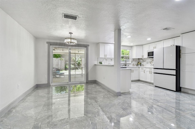 6200 13th Ave, New Port Richey, FL 34653 - kitchen with white appliances, light countertops, white cabinets, light marble finish floors, and a chandelier