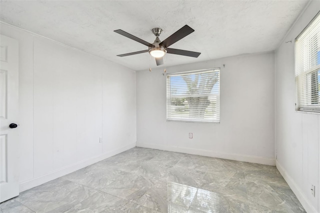 6200 13th Ave, New Port Richey, FL 34653 - unfurnished room featuring plenty of natural light, a ceiling fan, and marble finish floors