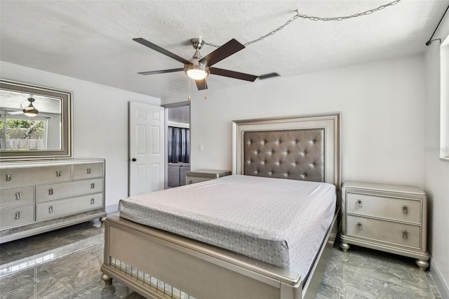 6200 13th Ave, New Port Richey, FL 34653 - bedroom featuring marble finish floors, a ceiling fan, and a textured ceiling