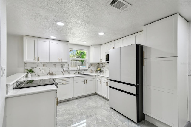 6200 13th Ave, New Port Richey, FL 34653 - kitchen featuring white appliances, a textured ceiling, white cabinets, light countertops, and recessed lighting