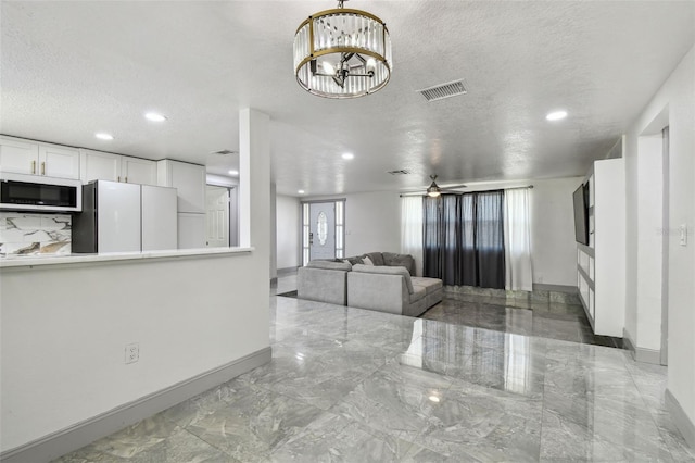 6200 13th Ave, New Port Richey, FL 34653 - living room with marble tiled flooring, a textured ceiling, recessed lighting, and a chandelier
