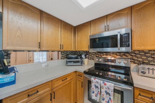 9205 Jakes Path, Largo, FL 33771 - kitchen with appliances with stainless steel finishes, light countertops, and decorative backsplash