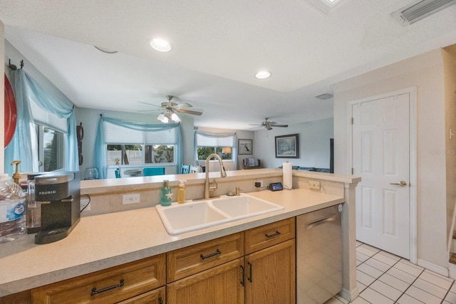9205 Jakes Path, Largo, FL 33771 - kitchen featuring stainless steel dishwasher, light tile patterned floors, light countertops, brown cabinetry, and recessed lighting