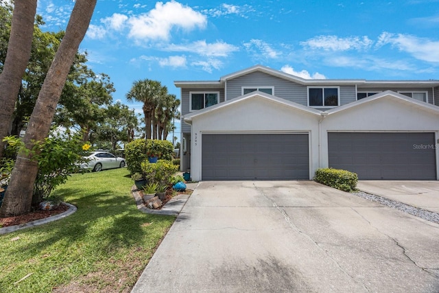 9205 Jakes Path, Largo, FL 33771 - view of front of house with driveway, a front lawn, stucco siding, and an attached garage