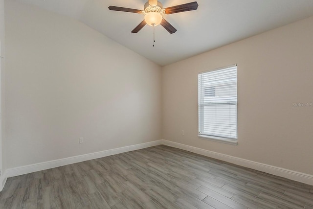 10915 Kirkwall Port Dr, Wimauma, FL 33598 - spare room featuring wood finished floors, vaulted ceiling, and a ceiling fan
