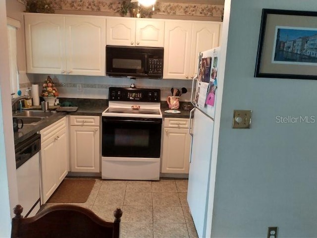 432 Flamingo Dr, Apollo Beach, FL 33572 - kitchen with white appliances, white cabinets, dark countertops, and light tile patterned flooring