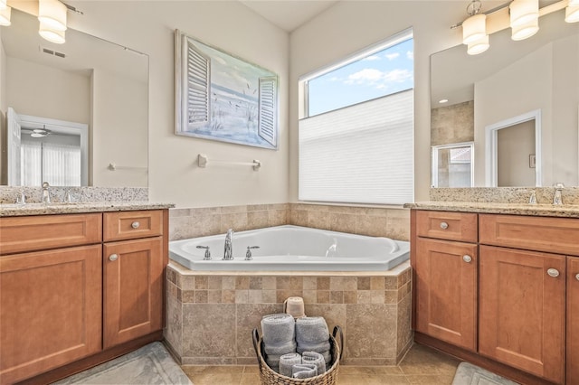 4911 Rock Island Ct, Wimauma, FL 33598 - bathroom featuring two vanities, a garden tub, a shower stall, and tile patterned floors