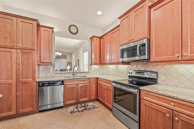 4911 Rock Island Ct, Wimauma, FL 33598 - kitchen with stainless steel appliances, decorative backsplash, light stone counters, light tile patterned floors, and recessed lighting