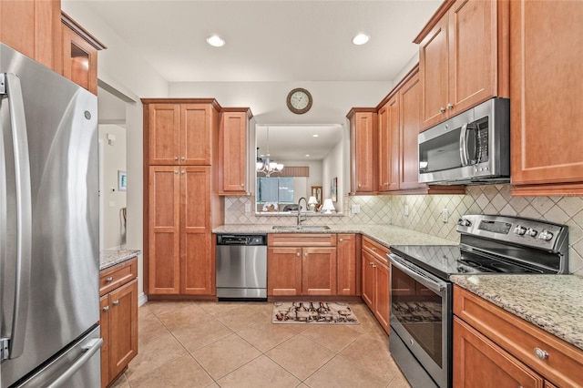 4911 Rock Island Ct, Wimauma, FL 33598 - kitchen featuring appliances with stainless steel finishes, backsplash, light stone countertops, a chandelier, and light tile patterned flooring