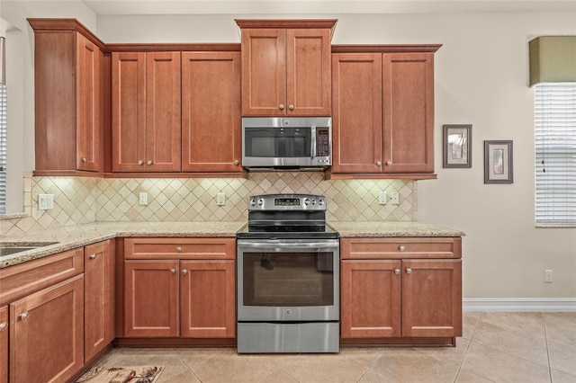 4911 Rock Island Ct, Wimauma, FL 33598 - kitchen with stainless steel appliances, tasteful backsplash, light stone counters, and light tile patterned floors