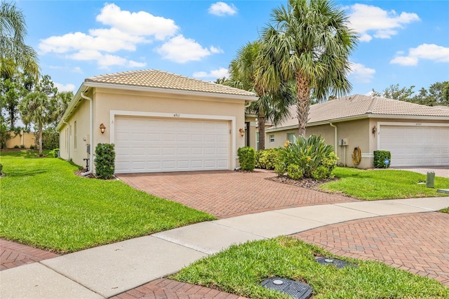 4911 Rock Island Ct, Wimauma, FL 33598 - view of front of home featuring stucco siding, a front yard, decorative driveway, and a tile roof