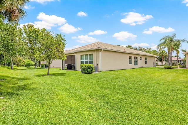 4911 Rock Island Ct, Wimauma, FL 33598 - back of house with stucco siding and a lawn