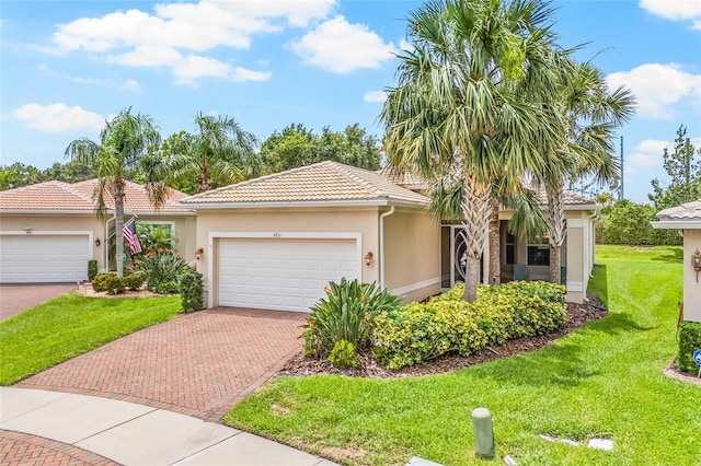 4911 Rock Island Ct, Wimauma, FL 33598 - view of front of house featuring a garage, decorative driveway, stucco siding, and a front lawn