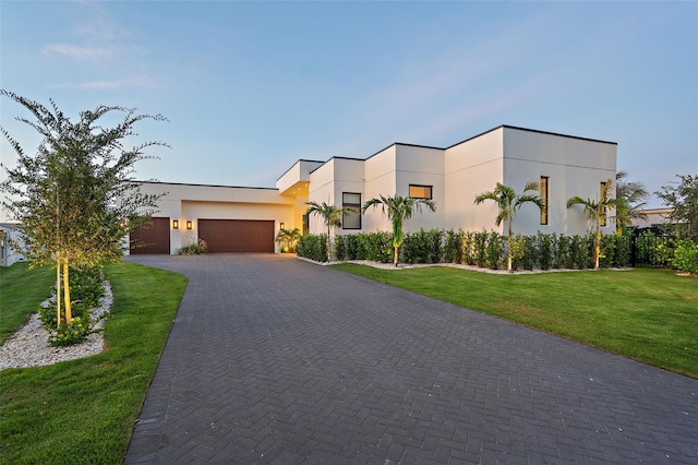 501 Barcelona Dr, Tierra Verde, FL 33715 - contemporary house with an attached garage, stucco siding, decorative driveway, and a front lawn