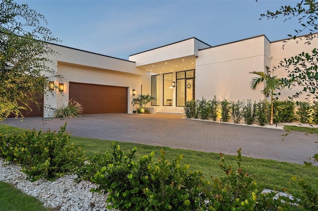 501 Barcelona Dr, Tierra Verde, FL 33715 - contemporary house featuring an attached garage, driveway, and stucco siding
