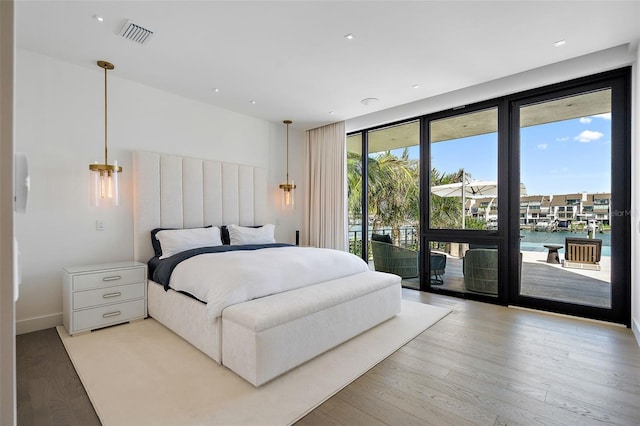 501 Barcelona Dr, Tierra Verde, FL 33715 - bedroom with access to outside, light wood finished floors, a wall of windows, recessed lighting, and a water view